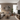Modern living room with beige sectional sofa, coffee table, and decorative elements.